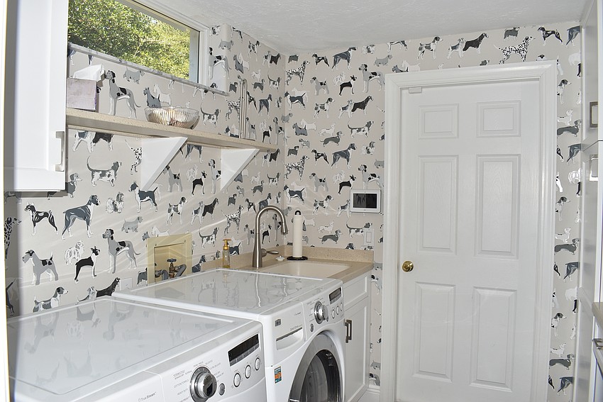 The laundry room is decorated with puppy wallpaper.