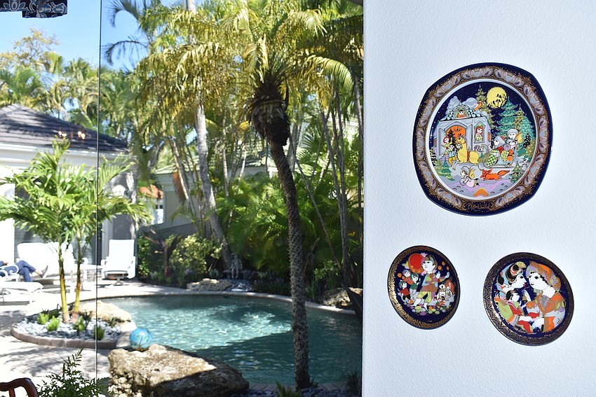 Decorative plates on a wall near a massive window.