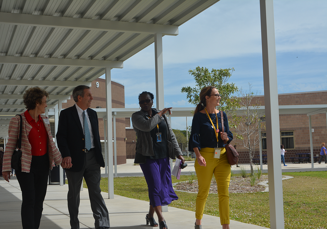 Harvard University president Lawrence Bacow (second from left) and his wife, Adele Bacow (far left), receive a tour of Booker High School on Wednesday afternoon.