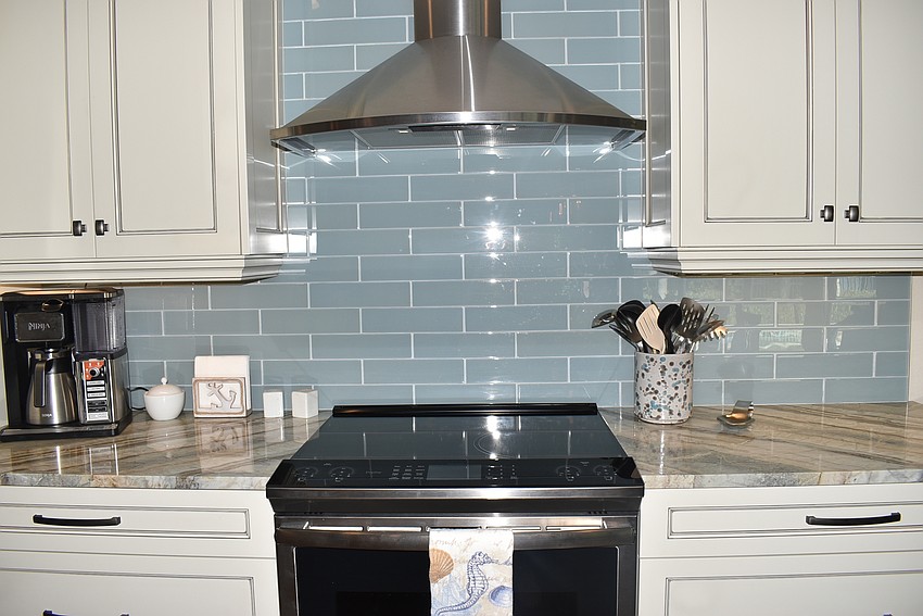 The kitchen features a bright blue backsplash.