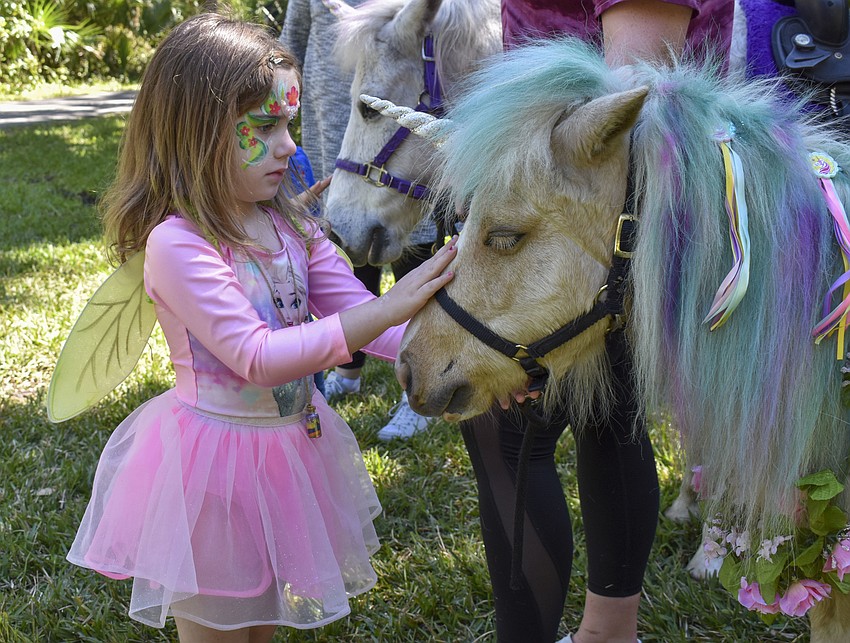 Erzsebet Boskey, 4, pets the unicorn.