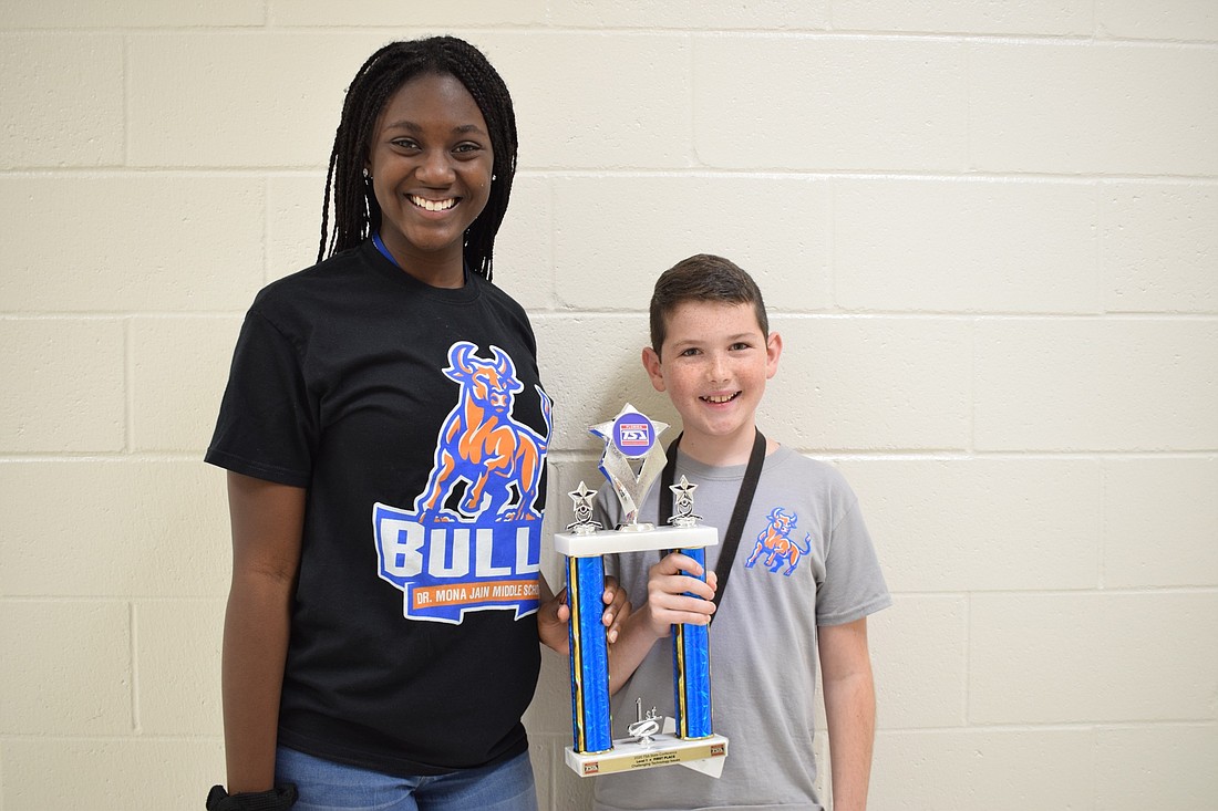 Laila Ward, an eighth grader, and Mason Engelsberg show off the trophy they received for placing first in Challenging Technology Issues during the Technology Student Association state competition.
