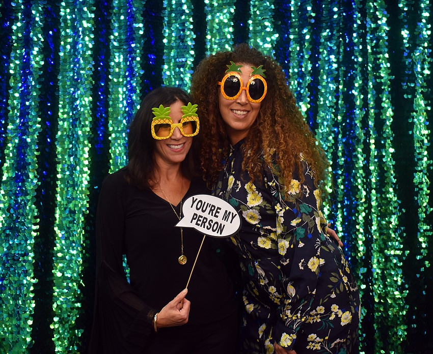 Lisa Roseman and Yael Belcher have fun at the tropical-themed photo booth.