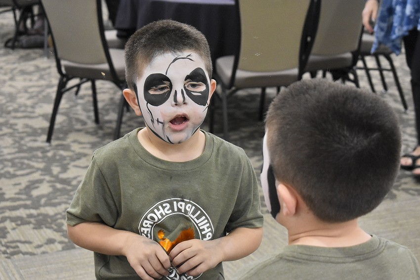 Abner Beck, 5, checks out his face paint in the mirror,