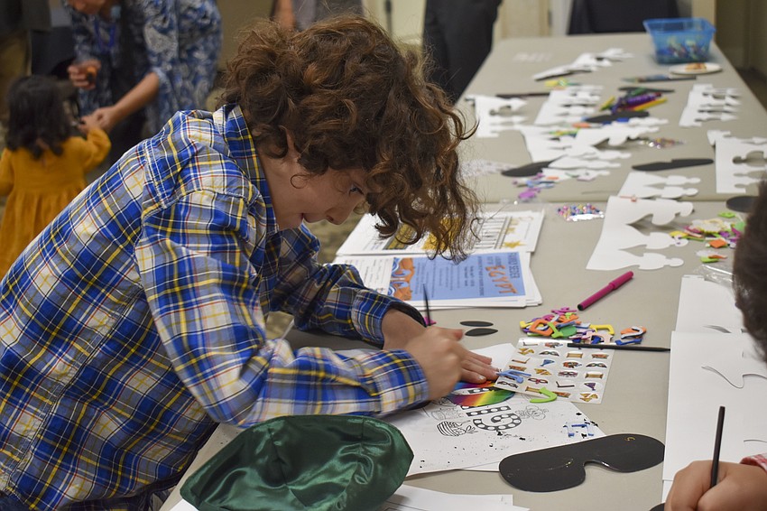 Logan Schwartz, 9, works on his Purim mask.