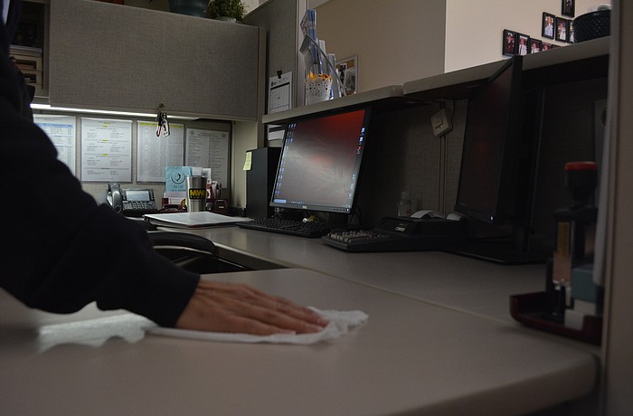 Longboat Key Fire Rescue Department EMS liaison/public information officer Tina Adams wipes her desk Monday morning at the Longboat Key north fire station.