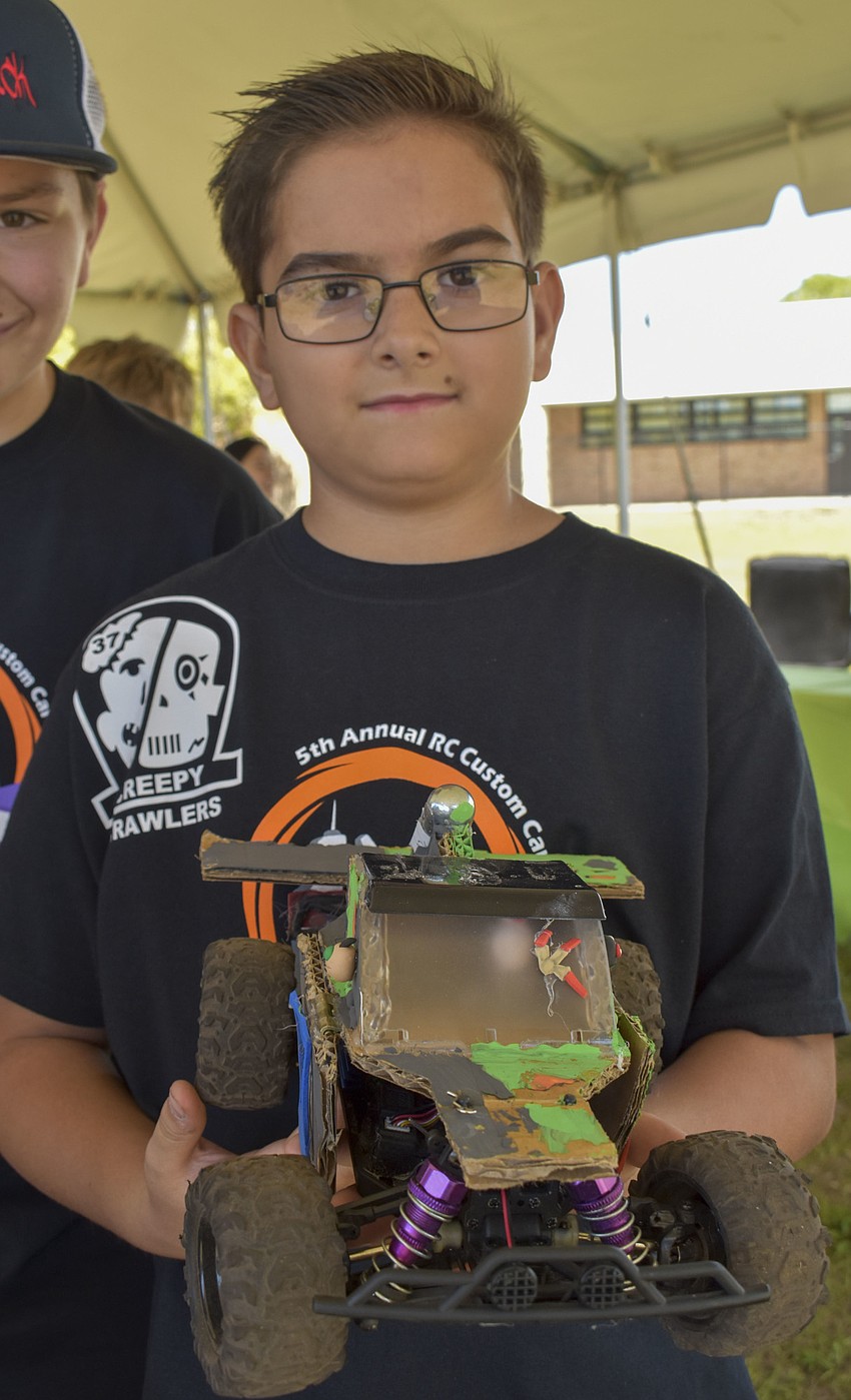 Evan Quinn, 11, holds up one of Wilkinson's remote control cars.