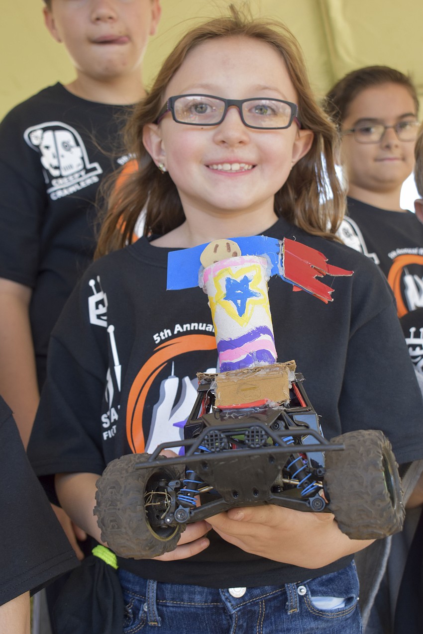 Jane Lee Klinger, 7, holds up one of Wilkinson's remote control cars.