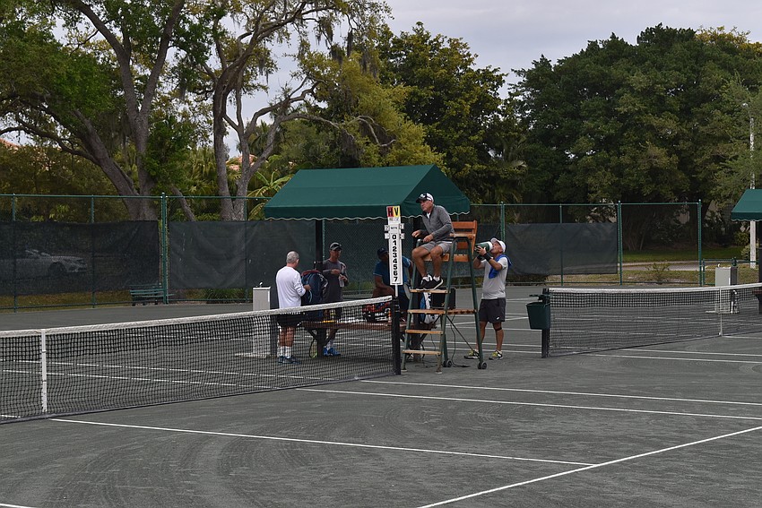 Players and the chair official get ready for the match.