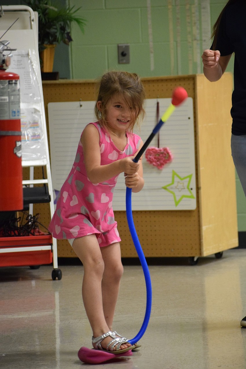 Scarlett Samson, a voluntary pre-kindergarten student, launches a rocket into the air. 