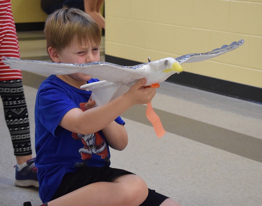 Zachary Malson, a second grader, aims before launching an eagle in a hallway.