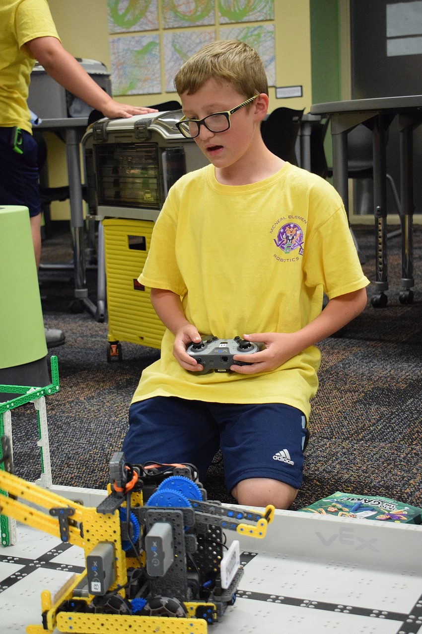 Aiden Howell, a fifth grader and member of Gilbert W. McNeal Elementary's robotics club, provides a robotics demonstration. Howell joined the club because he likes building. 