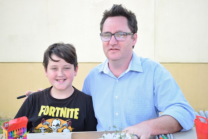 Drake Cohen, a fourth grader, spends time with his father, Tom, while going through the different stations. 