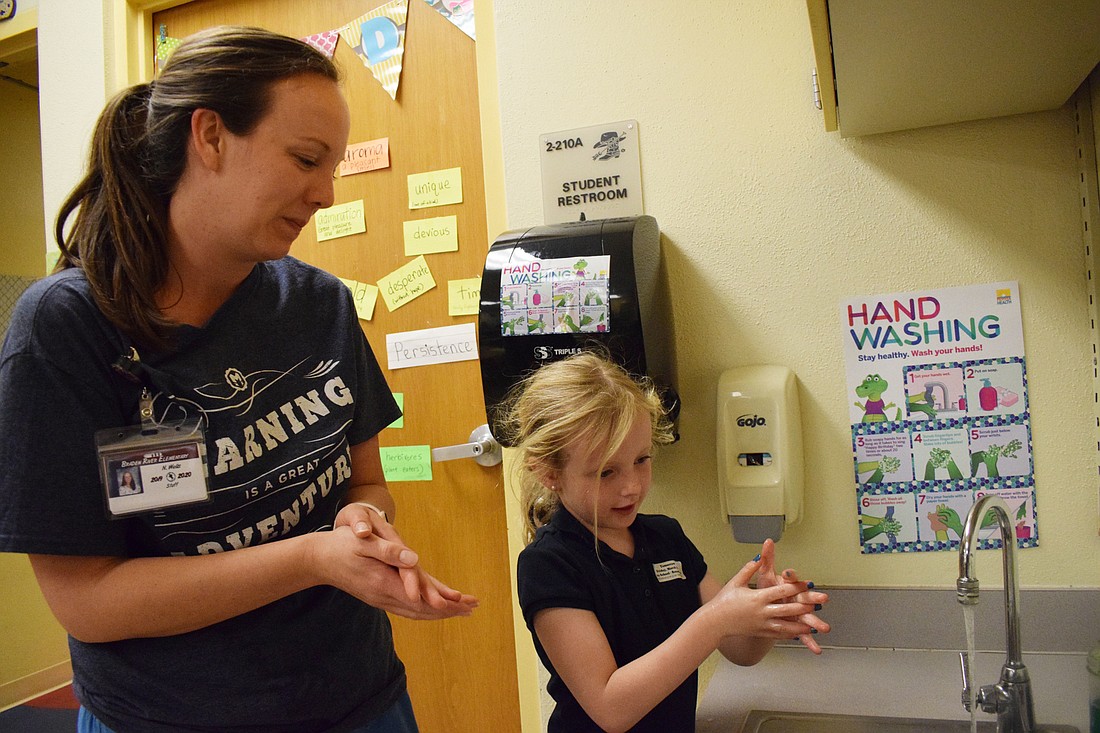 Braden River Elementary School nurse Nicole Wells and her daughter Penny, a kindergartner, sing a hand washing song to the tune of "Wheels on the Bus" while washing their hands. The Wells will not return to school until April 15.