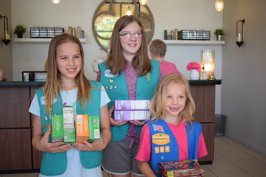 Alyssa Otterness and Allison Rothhaar of Girl Scout Troop 524 and Lauren Otterness of Troop 504 are selling their last batch of cookies. Booth sales were canceled due to the coronavirus causing them to be creative in their sales.