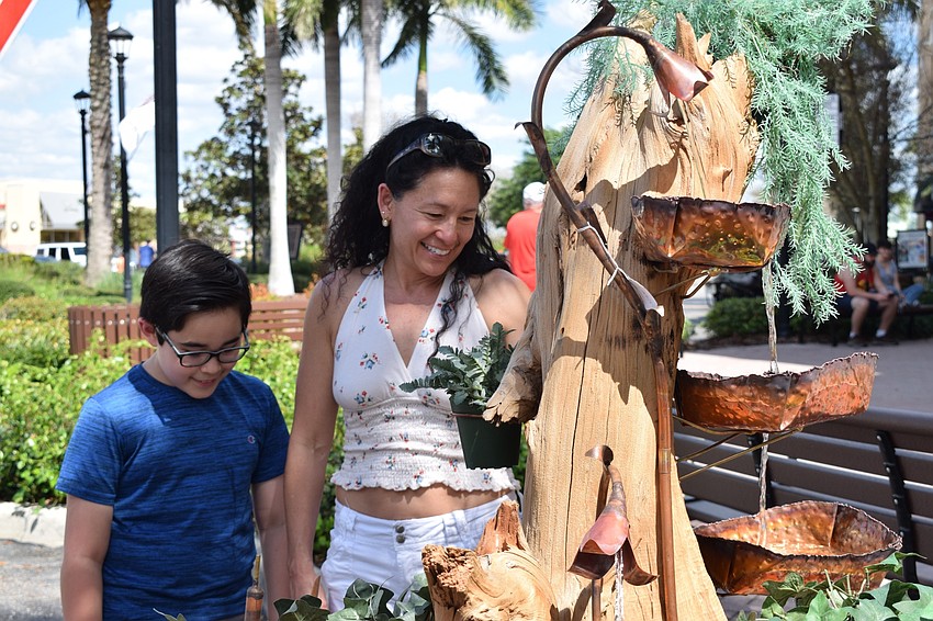 River Club residents Tai and Charlyn Gauthier look at a wood sculpture fountain. 