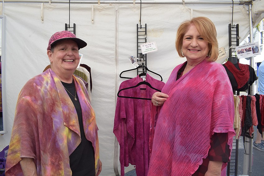 Shoshana Matthews shows Sarasota resident Pat Zagony the different ways she can wear a shawl Matthews made.