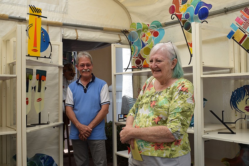 Ricky Espinosa talks about his wife, Josephina's, art with Sarasota Linda Shea. Shea likes the art festival because it includes several professional artists. 