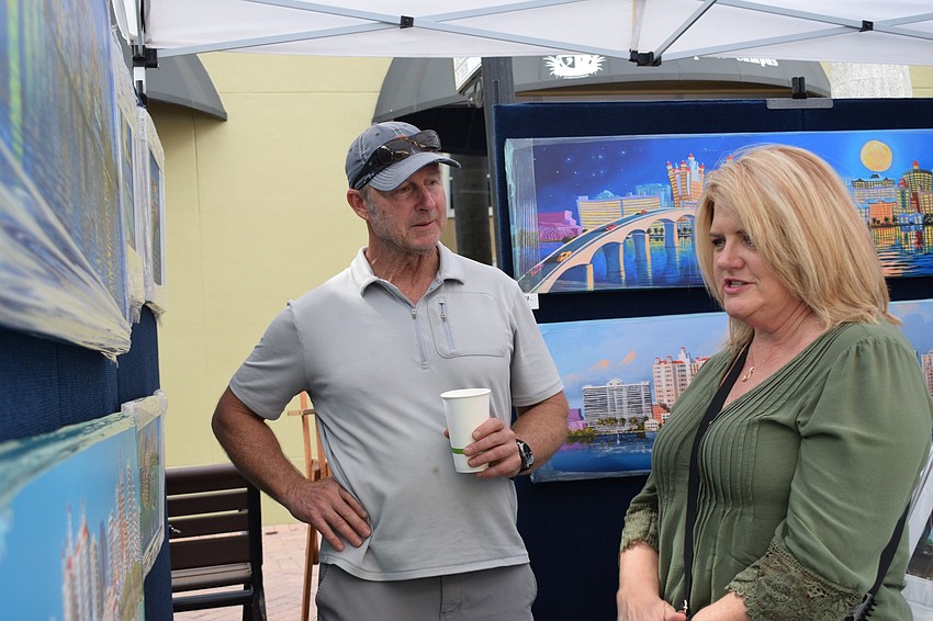 Artist Robert Johnson talks about his oil paintings of local areas with Lakewood Ranch resident Christy Simunovic. 