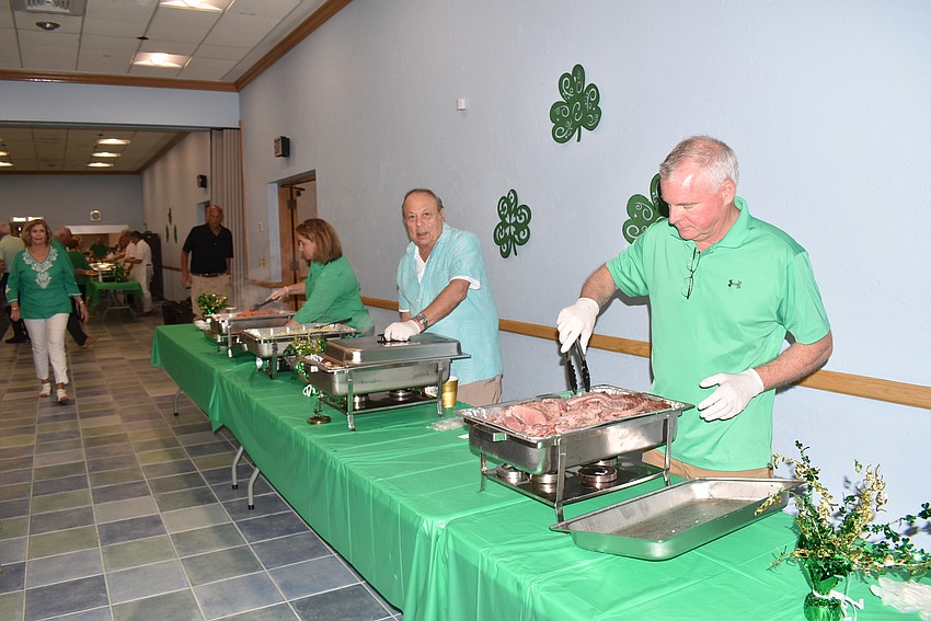 Gloved servers prepare dinner.