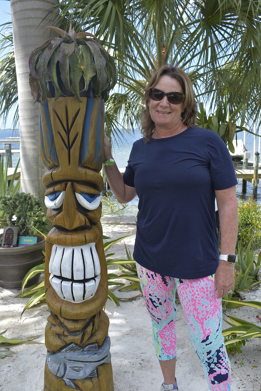 Karen Nicholson poses with a tiki sculpture.