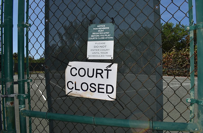 A sign indicates that the Longboat Key Tennis Center's courts are closed. The facility closed Sunday amid concerns about COVID-19.