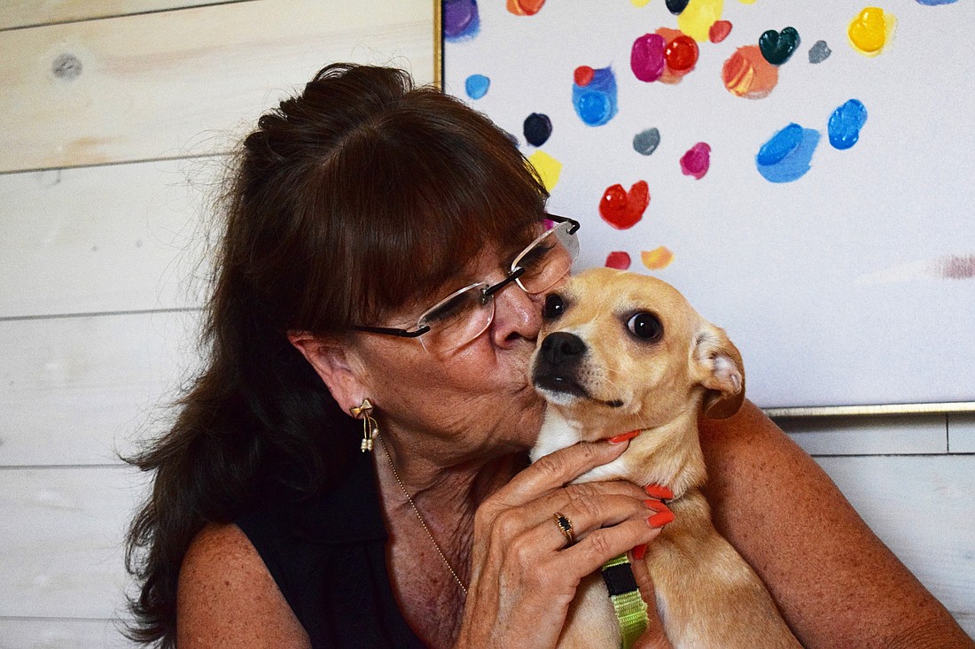 Kim Spruance, a Greyhawk Landing resident, kisses her new puppy, Bonita Chica.