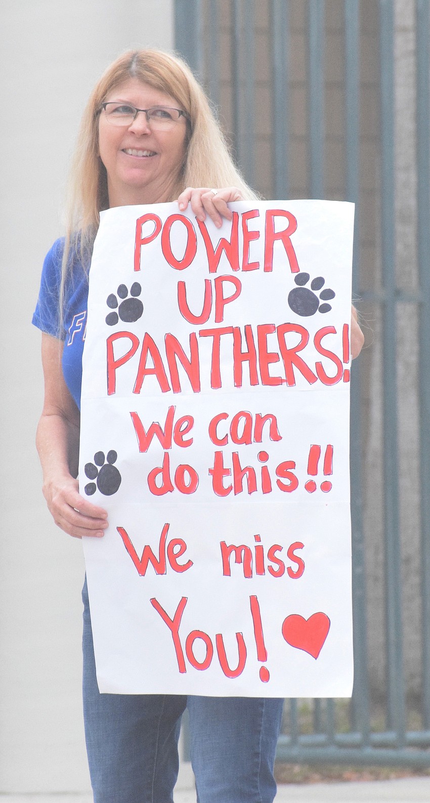 Heidi Enneking, an art teacher at Braden River Middle School, says goodbye to families as they leave after picking up their devices for online learning.