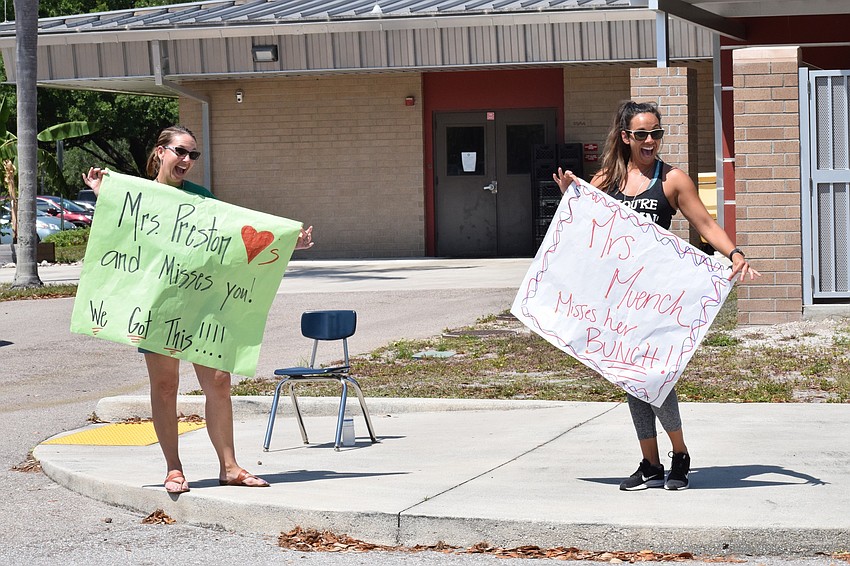 Cortney Preston and Angelica Muench, fifth grade teachers at Braden River Elementary School, show off their handmade signs.