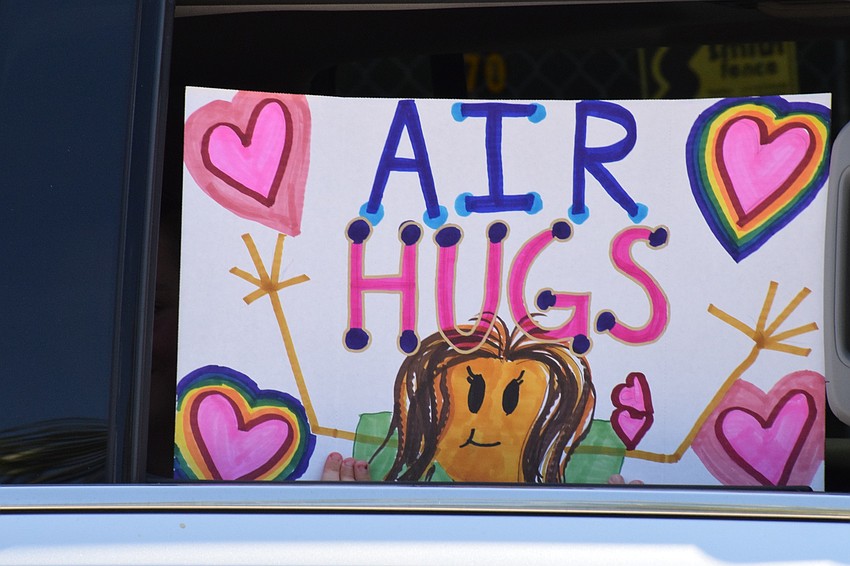 While a family drives by with a student holding an 