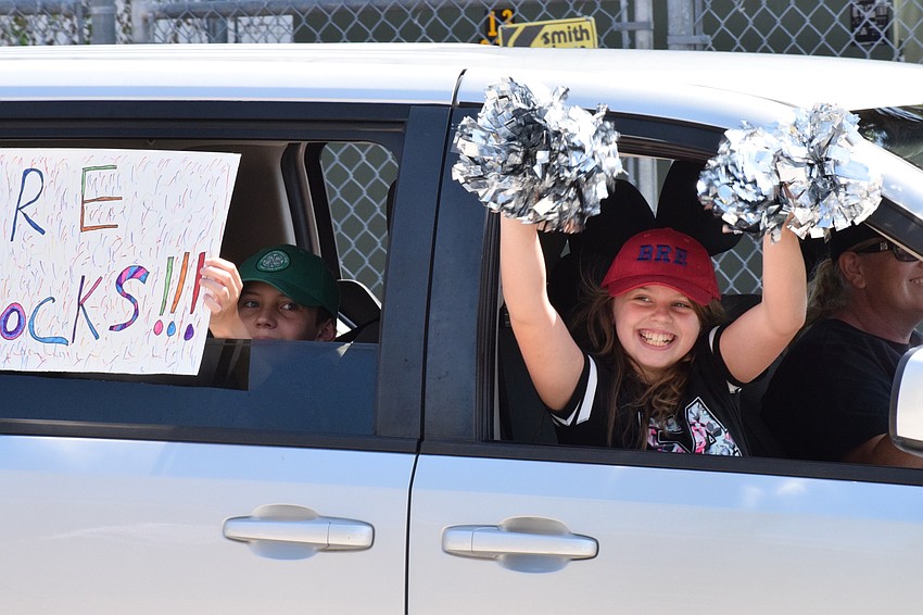 Joseph and Alice Barr cheer on teachers as they go by during an e-learning kickoff parade at Braden River Elementary School.