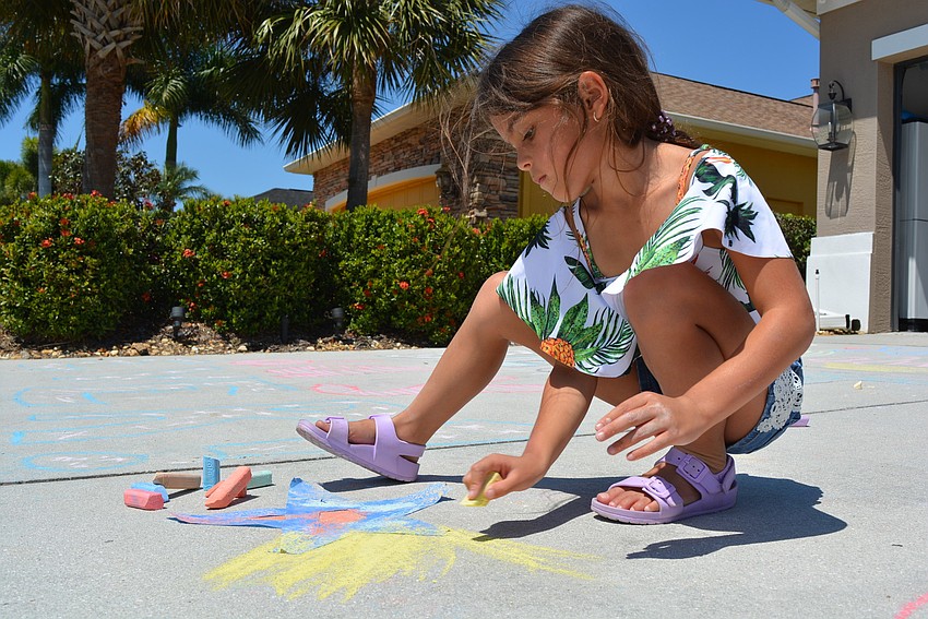 Six-year-old Catalina Poole adds color around  a star she created from painter's tape.