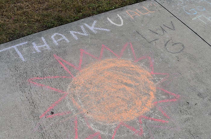 Messages of gratitude decorate the sidewalks outside of Country Club Shores.