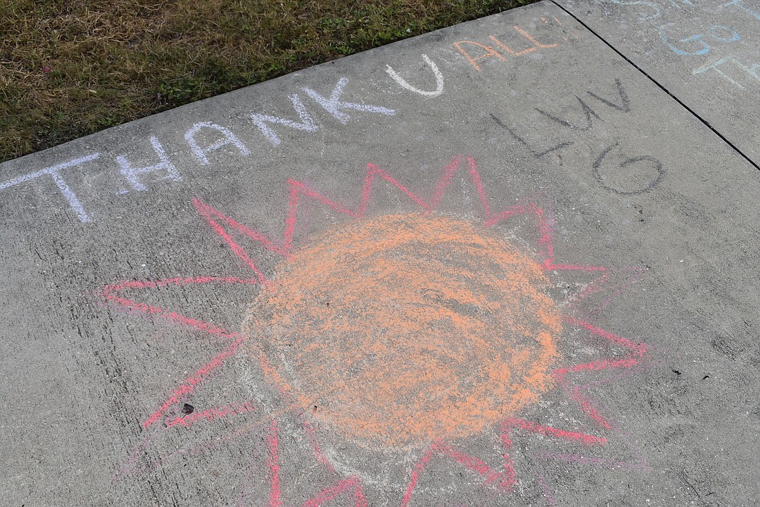 Messages of gratitude decorate the sidewalks outside of Country Club Shores.