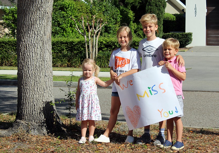 The Mangum family waits for the teachers to drive by.