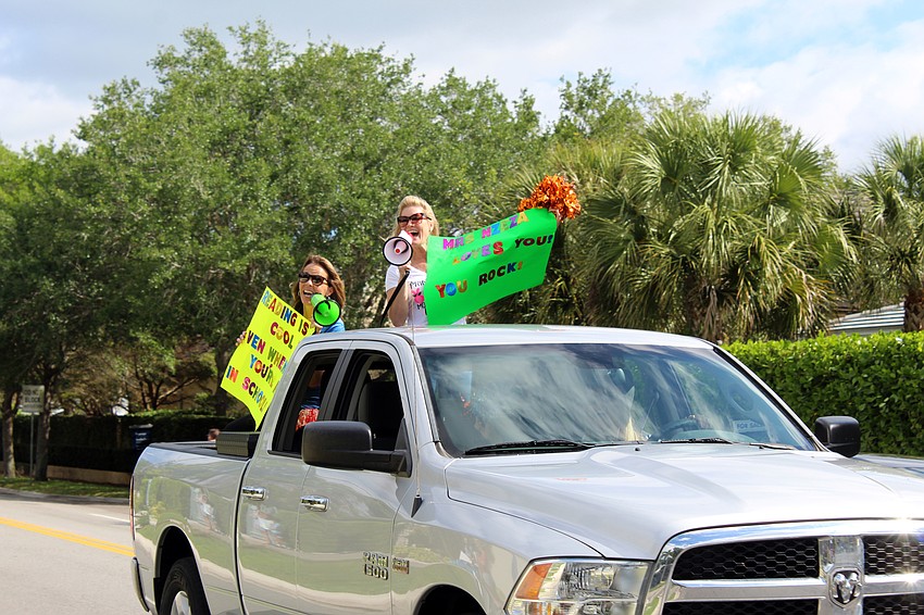 Principal Jennifer Nzeza and teacher Jennifer Smith lead the parade, talking to students with a bullhorn along the route.