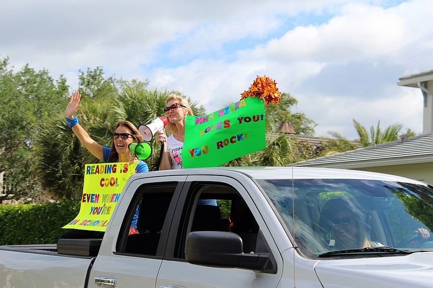 Principal Jennifer Nzeza and teacher Jennifer Smith lead the parade, talking to students with a bullhorn along the route.
