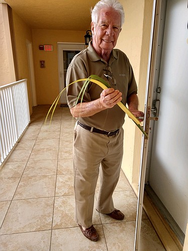 Bruce Schaefer leaves palms at a neighbor&#39;s door.