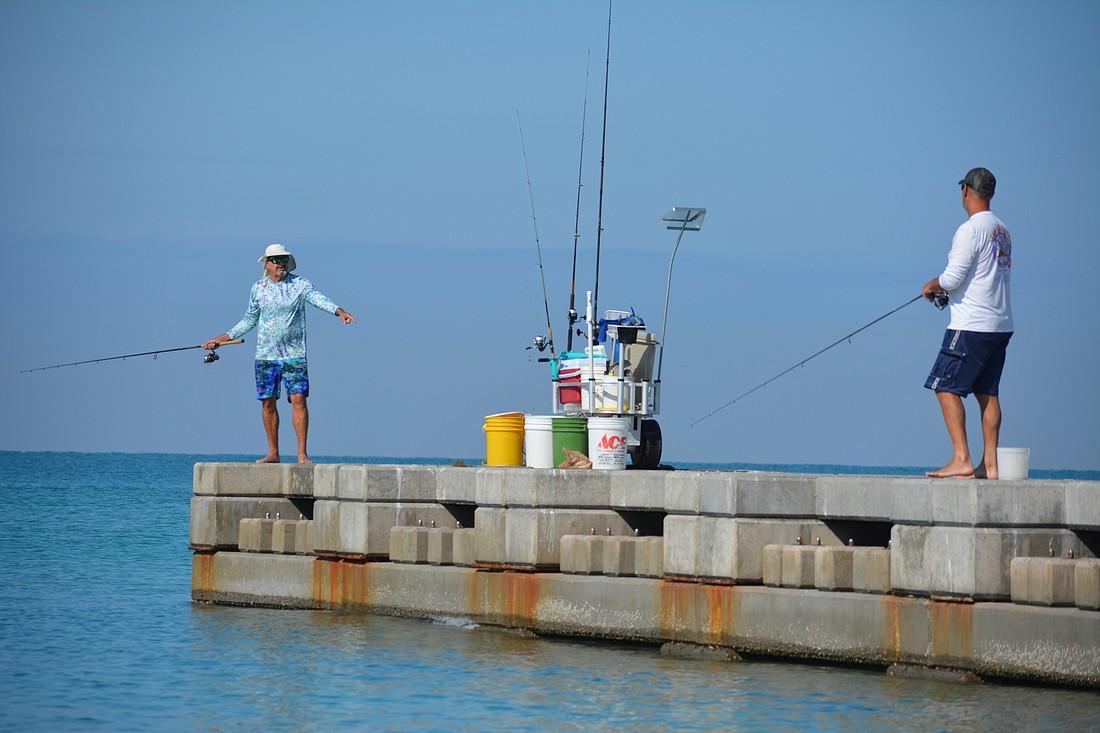 Beach Fishing Adventures proprietor Steven Herich (left) communicates with former client, now-friend Steve Nicolai while fishing Saturday on Longboat Key.