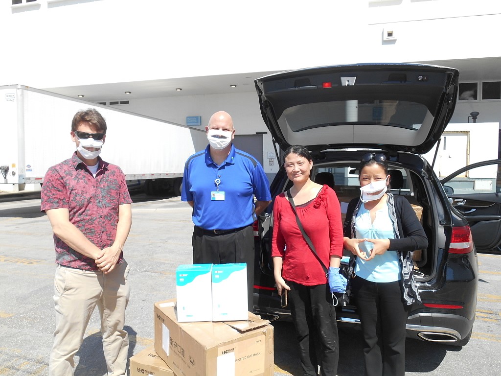 Josh Sinclair, left, Joanna Peng and Sunny Hannly present Sarasota Memorial Hospital&#39;s  Robert Milano with 2,000 high-quality respirator masks they were able to buy through contacts in China. (Photos courtesy of Joshua Sinclair)