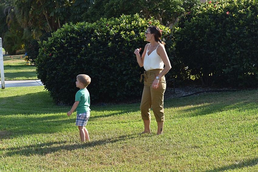 Finn and Melanie Deloie interact with neighbors from the safety of their lawn.