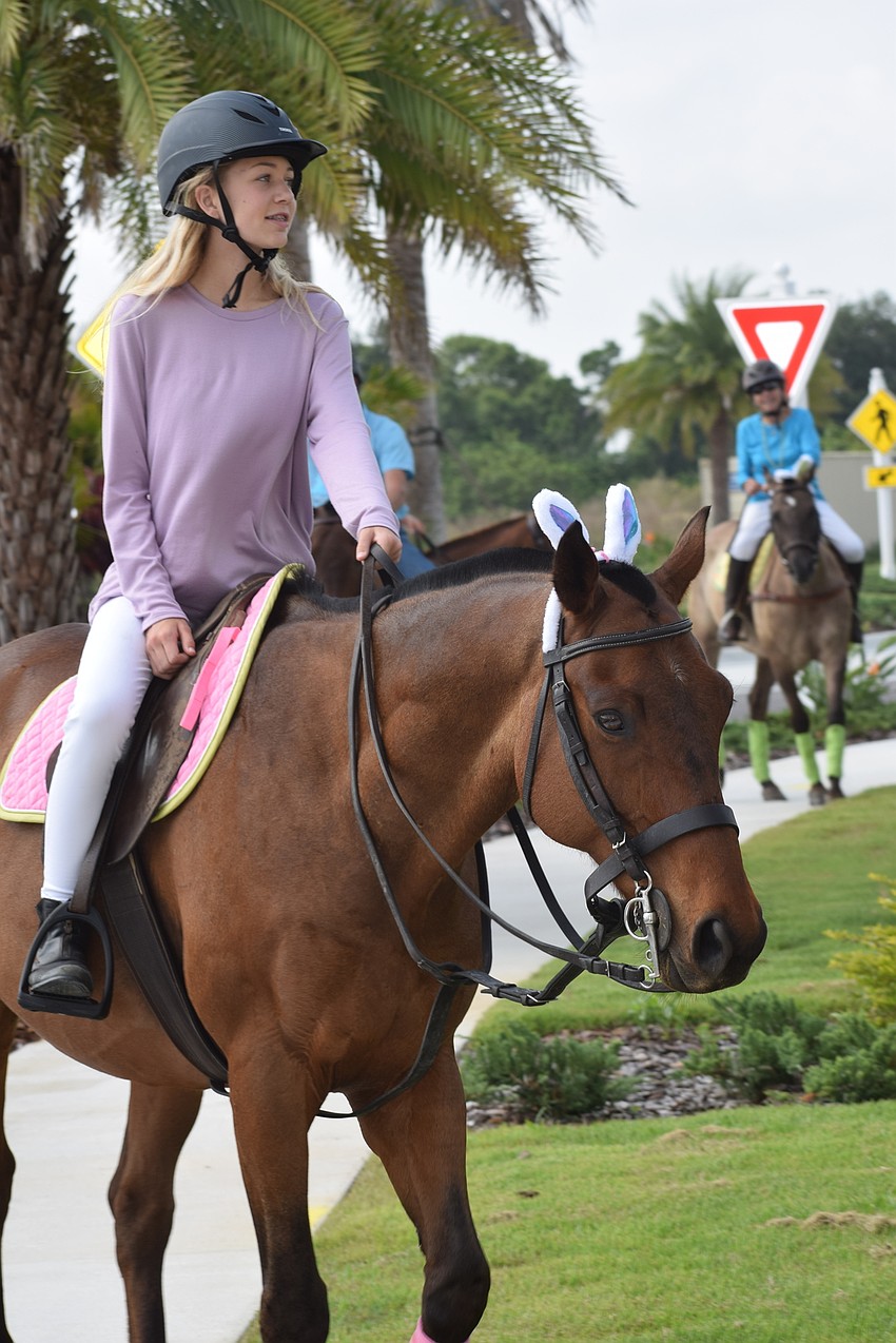 The Sarasota Polo Ranch's Alexa Hornung, 13, circles Grand Living with the parade riders.