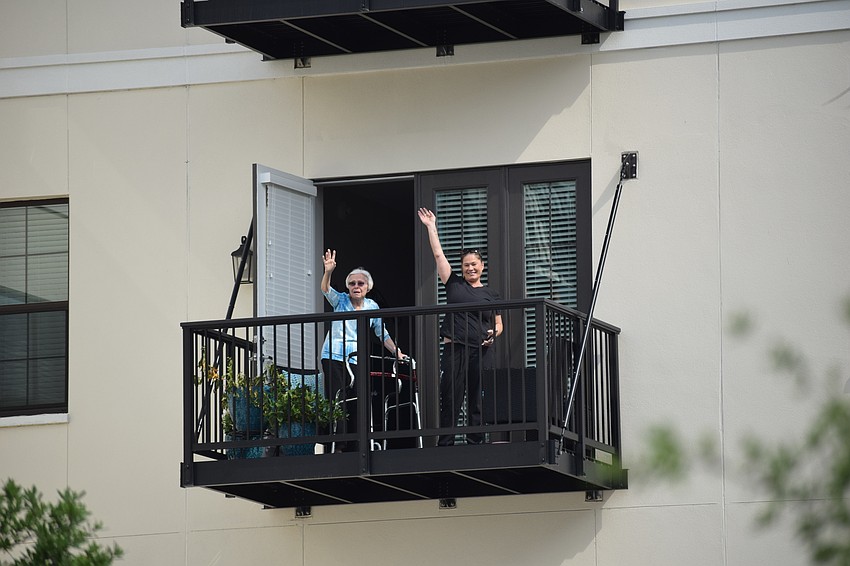 Residents and employees of Grand Living wave to the riders as they circled the building.