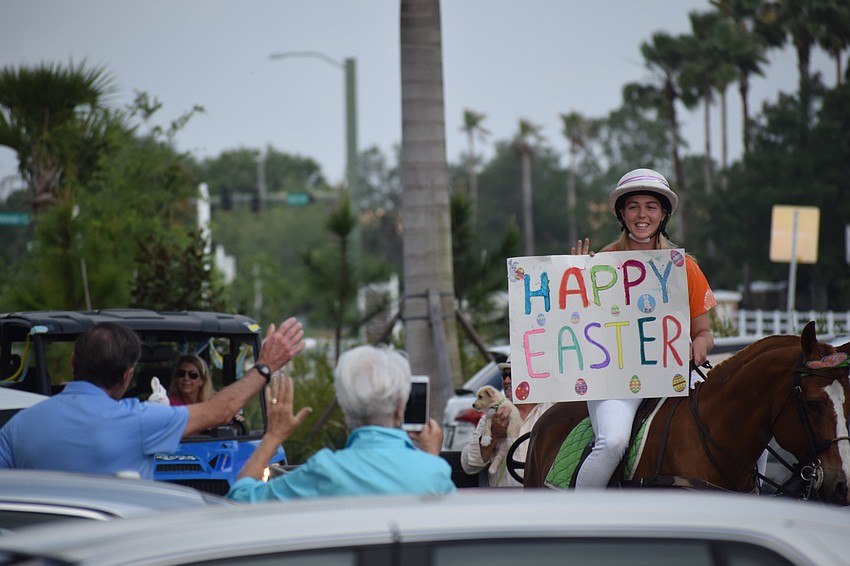 Residents at Grand Living at Lakewood Ranch wave as Pippa Campbell passes.