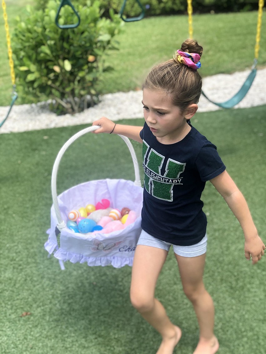 Charlie Johnson, 4, of the River Club races to find more Easter eggs for her basket.