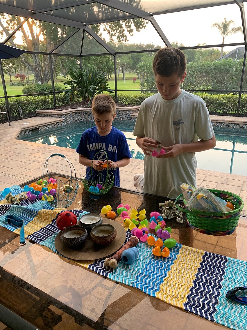 Riley and Brady Pope of River Club take apart the plastic eggs they found to find Easter treasures.