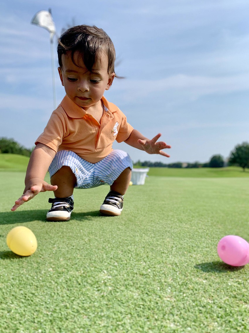 One-year-old Niko Rossi Sharma finds Easter eggs on the No. 3 hole of the King’s Dune Course in Lakewood Ranch. He is the grandson of Gloria Bracciano and Greg Van Natter.