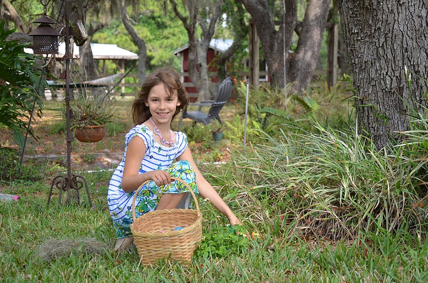 Amelia Hemmer, 8, fills her basket during an Easter Sunday egg hunt in East County.