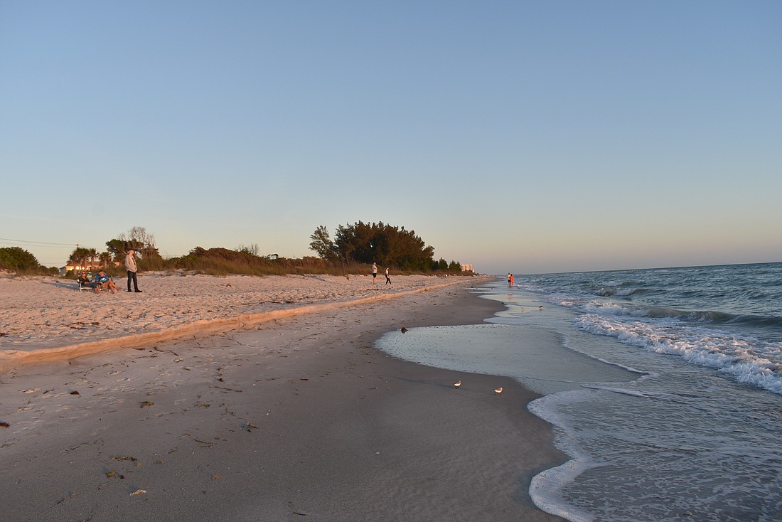 Beachgoers  keep their distance during a Longboat Key  sunset.