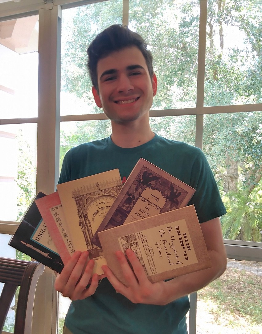 Temple Emanu-El Livestream Seder participant Moses Glickman displays his family’s collection of Haggadahs – the book of rituals, readings, and prayers used during the Seder meal.